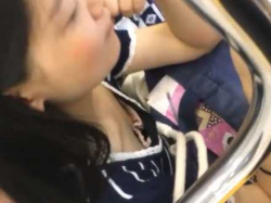電車内で胸チラ！スマホをイジってる隙に乳首を狙われる胸元全開ぺちゃぱいギャルの画像