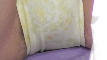 【eros2793座りパンチラ】フロントモッコリで黄色花柄の薄黄色Pのサイドからハミ毛し座りパンチラする若い娘の画像