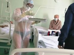 ロシア看護婦がブラジャーとパンティーの上に透明の防護服でコロナ治療の画像
